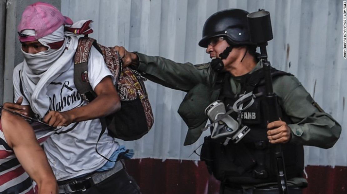 Un miembro de la Guardia Nacional Bolivariana agarra a un protestante de la oposición este jueves en Caracas.