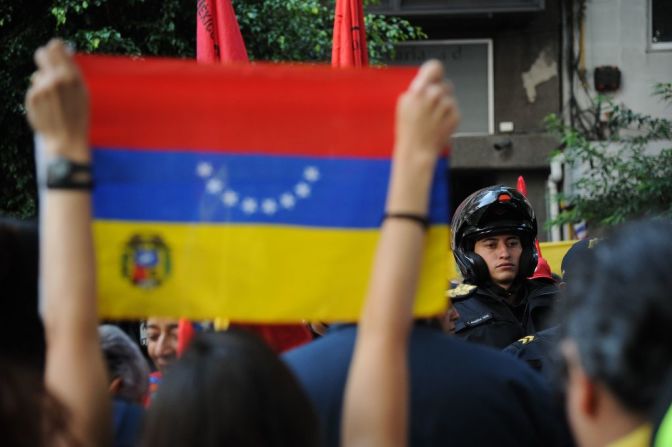 Un agente de policía separa a los miembros del Frente Popular Francisco Villa (d), que apoyan al presidente venezolano, Nicolás Maduro, y miembros de la comunidad venezolana en México, que se manifiestan en contra de las elecciones para la Asamblea Constituyente en la embajada de Venezuela en Ciudad de México este 30 de julio de 2017.