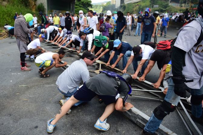 Activistas opositores establecen barricadas durante una protesta contra las elecciones para la Asamblea Constituyente en Caracas este 30 de julio de 2017. Uno de los candidatos en la elección, el abogado José Félix Pineda, fue asesinado el sábado por la noche en su casa y las autoridades dijeron que estaban investigando.