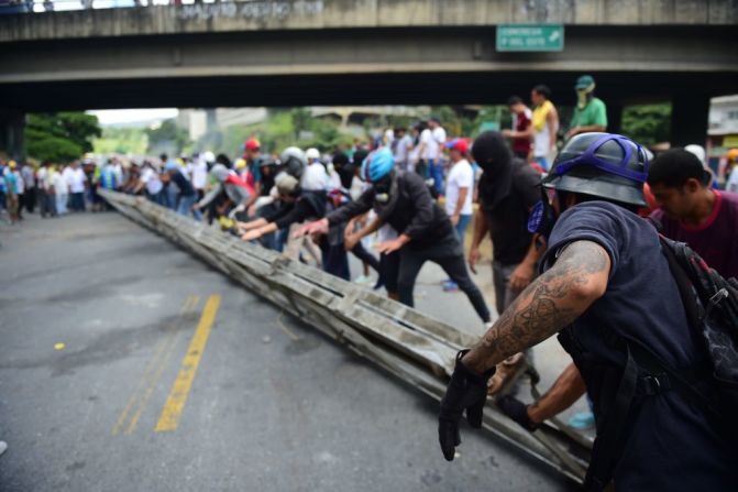 Activistas opositores establecen barricadas durante una protesta contra las elecciones para la Asamblea Constituyente en Caracas este 30 de julio de 2017. La policía bolivariana lanzó gas lacrimógeno y perdigones en enfrentamientos contra manifestantes.