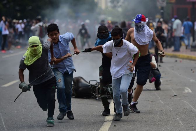 Activistas opositores arrastran una motocicleta policial durante una manifestación en contra de la Asamblea Nacional Constituyente en Caracas este 30 de julio del 2017.