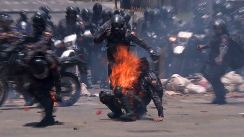 Momento de la explosión de un artefacto sobre el cuerpo de un policía durante una manifestación contra las elecciones para la Asamblea Constituyente en Caracas este 30 de julio de 2017. Los venezolanos elegirán a los 545 representantes de una asamblea que tendrán el poder de reescribir la constitución de 1999 y disolver las instituciones del Estado actuales.