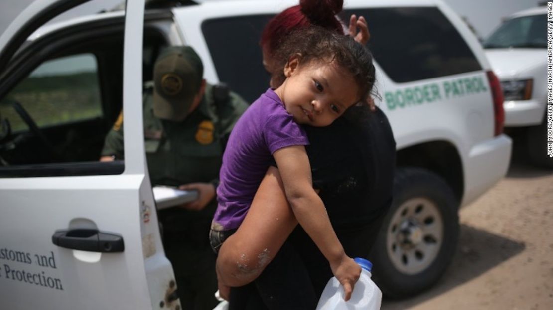 Una mujer de El Salvador y su hija de 3 años esperan el transporte para ir a un centro de inmigración luego de que cruzaran el Rio Grande en Estados Unidos el 24 de julio de 2014.