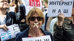 TOPSHOT - A protester with tape covering her mouth takes part in the March for Free Internet in central Moscow on July 23, 2017. / AFP PHOTO / Mladen ANTONOV