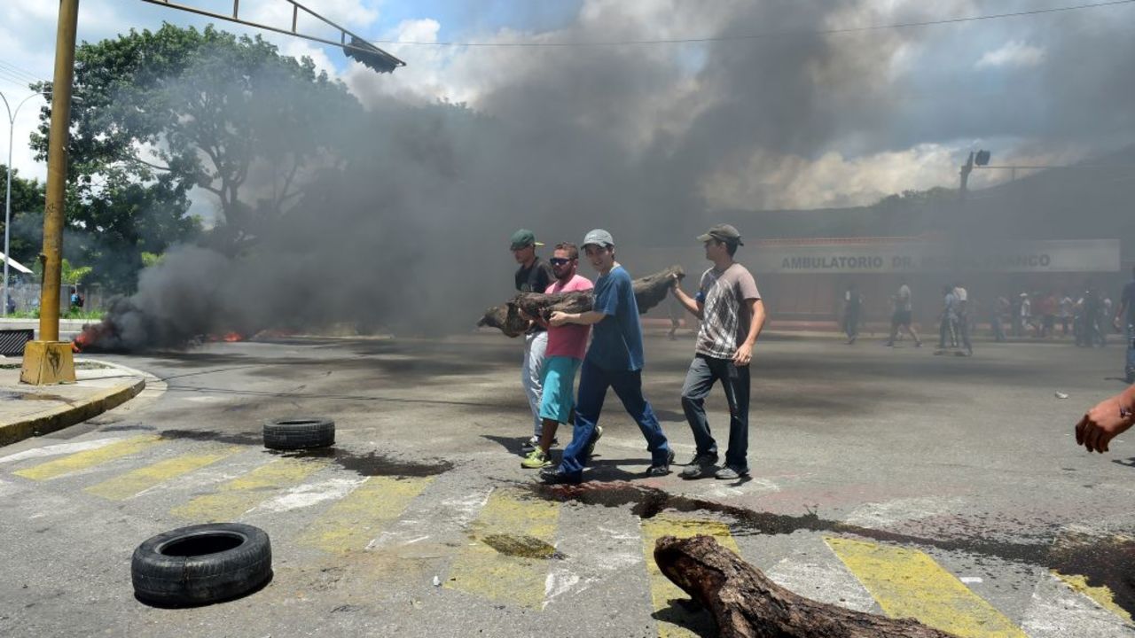 Manifestantes opositores se enfrentan a la Guardia Nacional Bolivariana durante disturbios en la ciudad de Valencia, tras la sublevación militar. El gobierno dice que esta ha sido controlada.