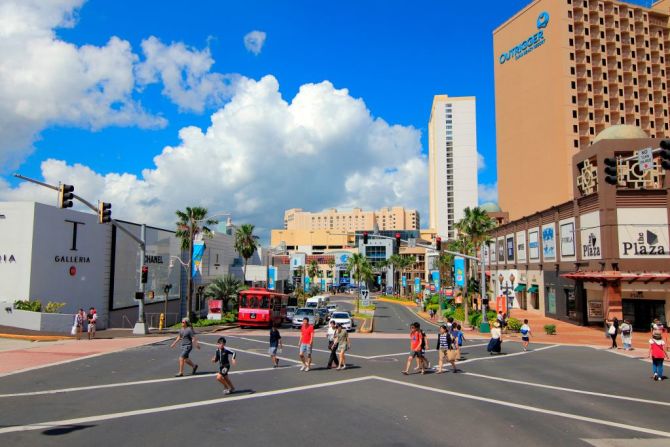 Turistas cruzan una vía cerca de un centro turístico en Tamuning.