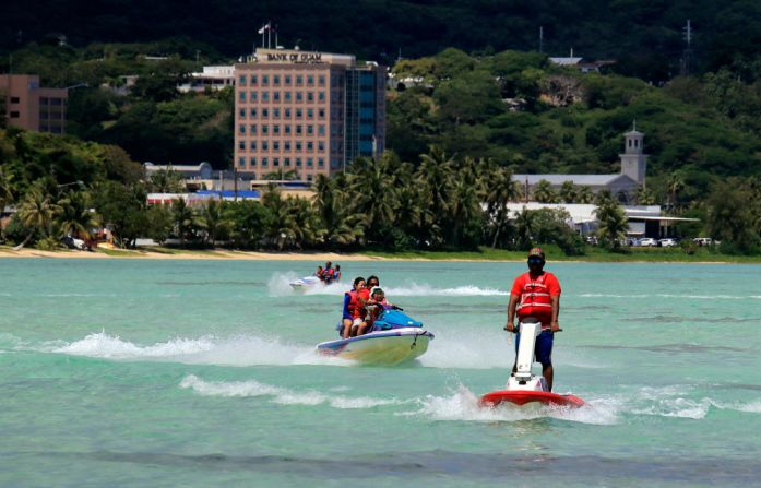 Los turistas disfrutan de las actividades en la playa de Tumon, Guam.