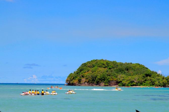 Los turistas disfrutan de las actividades cerca de la playa de Tumon en la isla de Guam el 11 de agosto de 2017. Guam, cuya economía depende del turismo, busca sacar provecho de su nueva fama como blanco de un posible ataque de Corea del Norte: aprovecha una improbable oportunidad promocional para atraer visitantes a la idílica isla y demostrar que toda publicidad es buena publicidad.