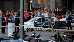 Un grupo de personas abandonan un restaurante de comida rápida con las manos en la cabeza, evacuadas por la policía de Barcelona.