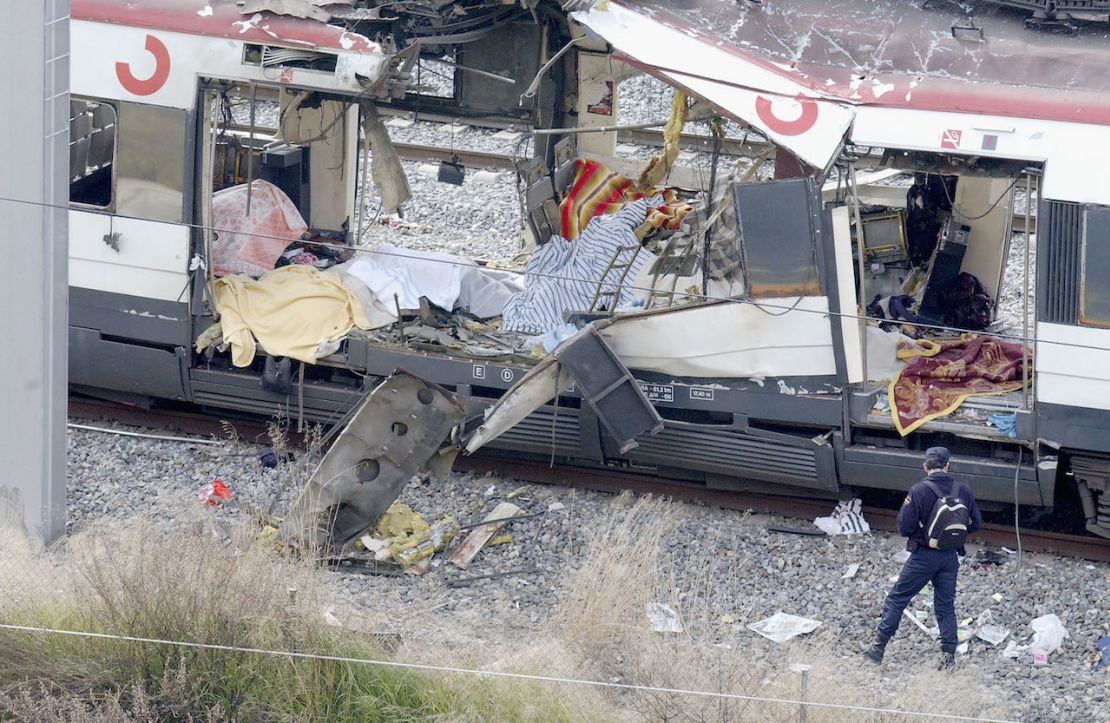 Rescatistas buscan en los restos de un tren de cercanías el 11 de marzo de 2004 después de que fue devastado por una explosión de bomba durante la hora pico de la mañana en Madrid, España.