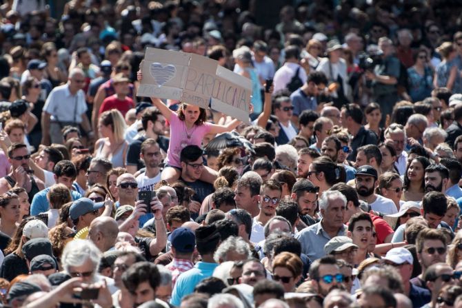 Una niña sostiene un cartel en medio de la multitud durante la vigilia en la que participaron miles de personas.