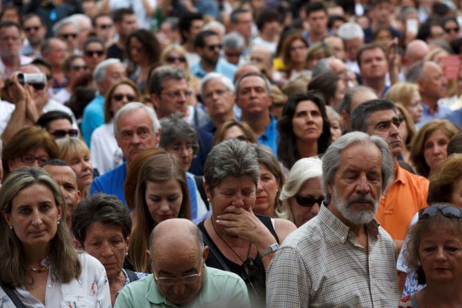 Una mujer llora en medio de la multitud.