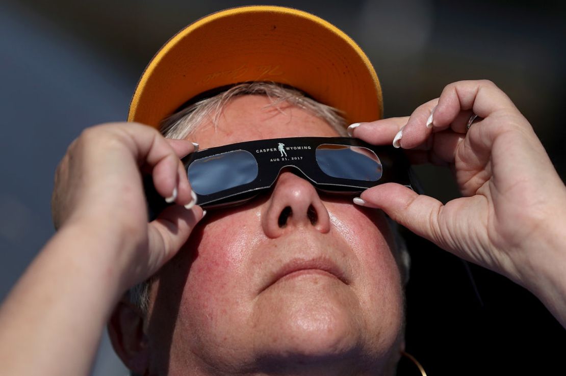 Una mujer usa unas gafas especiales para ver hacia el Sol.