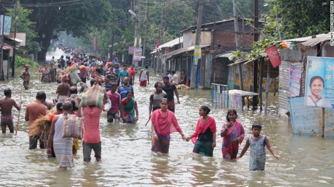 Residentes caminan a través de la inundación en el estado indio de Bengala Occidental el 17 de agosto.