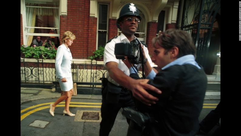 Un policía aleja a un fotógrafo de Diana, en julio de 1986. Se acababa de anunciar su divorcio de Carlos.