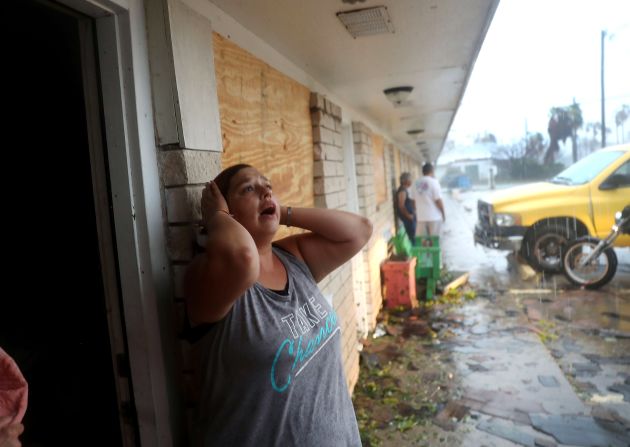 Una residente de Rockport, Texas, se entera de que una amiga podría seguir en su apartamento, que fue destruido por el huracán Harvey. Al fondo, las torrenciales lluvias.