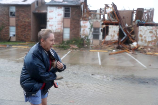 Los habitantes de Rockport (Texas), donde la magnitud del huracán se ha sentido con mayor intensidad, han salido de sus hogares para buscar refugio. En la imagen, una mujer protege a su perro con la chaqueta mientras camina por el complejo de apartamentos donde vive.