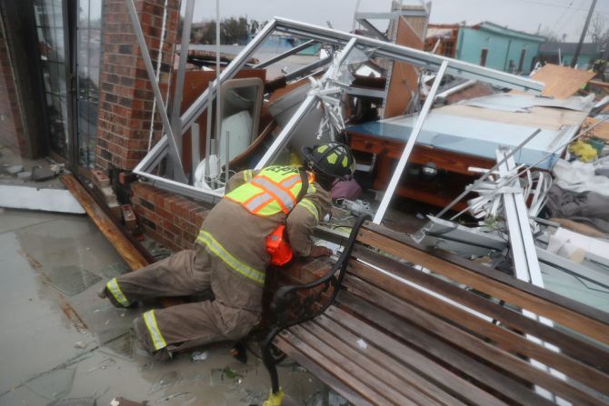 Un bombero de Rockport busca puerta a puerta a personas que puedan necesitar ayuda en medio de una operación de rescate tras el huracán Harvey que tocó tierra poco después de las 11 p.m. de este viernes.