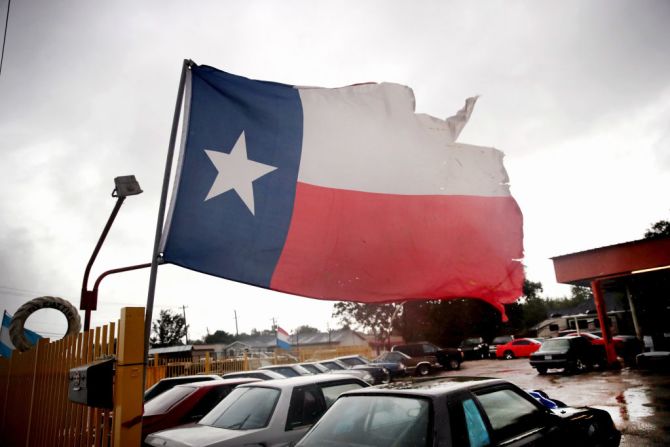 La bandera de Texas se ondea con los fuertes vientos provocados por la tormenta tropical en Houston, Texas. Harvey tocó tierra en Corpus Christi la noche anterior y espera que deje lluvias torrenciales a su paso.