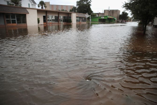 El agua empieza a drenar en una calle inundada en Galveston, Texas, por lluvias del huracán Harvey.