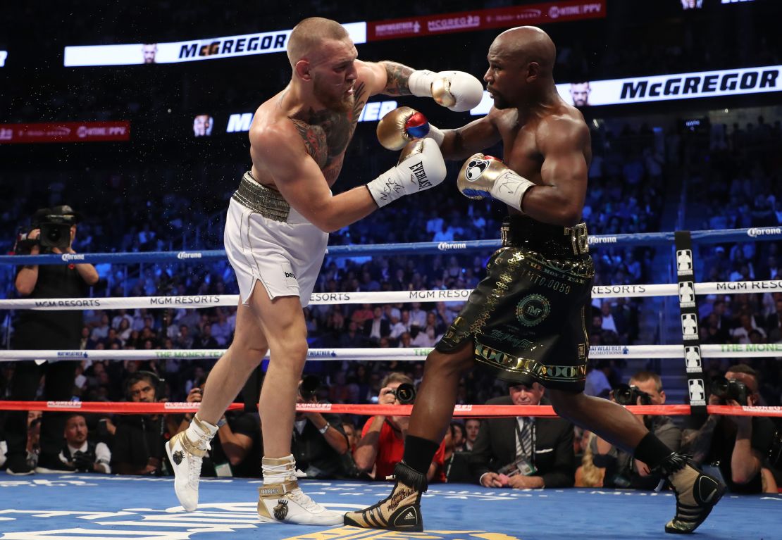 Mayweather Jr. y McGregor intercambian golpes durante su pelea en Las Vegas.