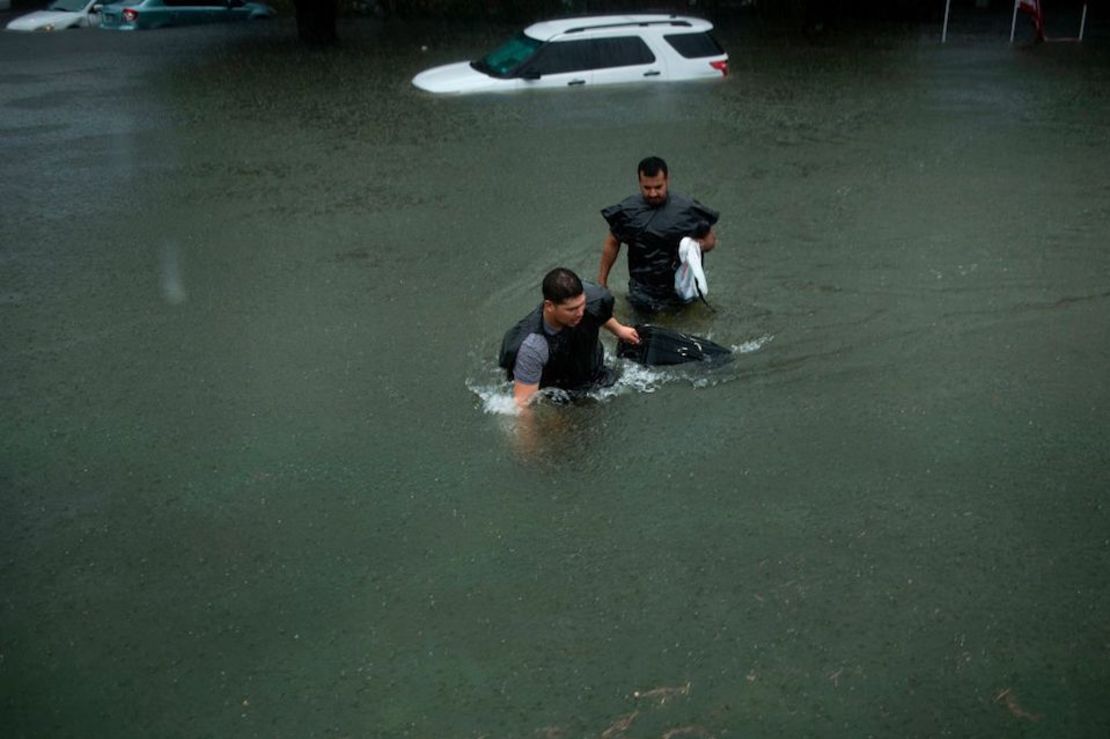 Personas caminan por una calle inundada de Galveston, Texas.