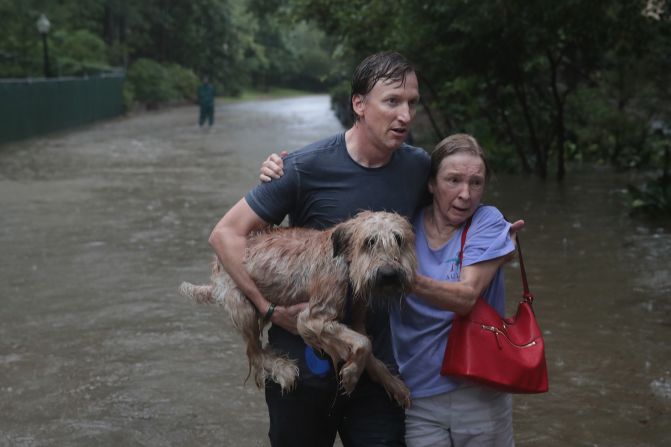 Andrew White (izq.) ayuda a una vecina después de rescatarla de su hogar en su barco en el barrio de River Oaks el 27 de agosto de 2017 en Houston, Texas. Crédito: Scott Olson / Getty Images