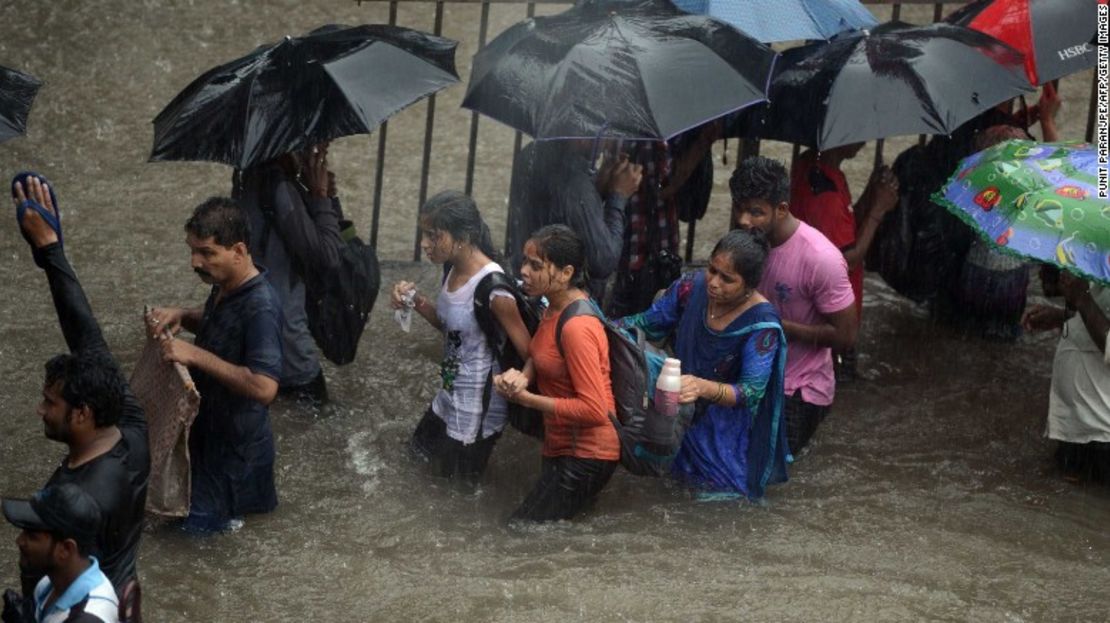 Residentes locales caminan por una calle inundada durante las fuertes lluvias en Mumbai este martes.