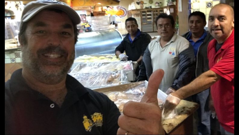 Los panaderos junto con la policía que llegó para ayudarles a repartir los panes.