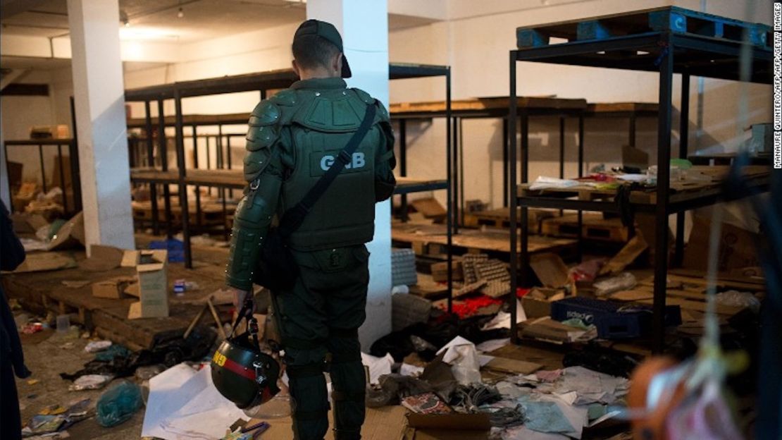 Un miembro de la Guardia Nacional de Venezuela vigila los escombros en un supermercado saqueado en Venezuela en 2016.