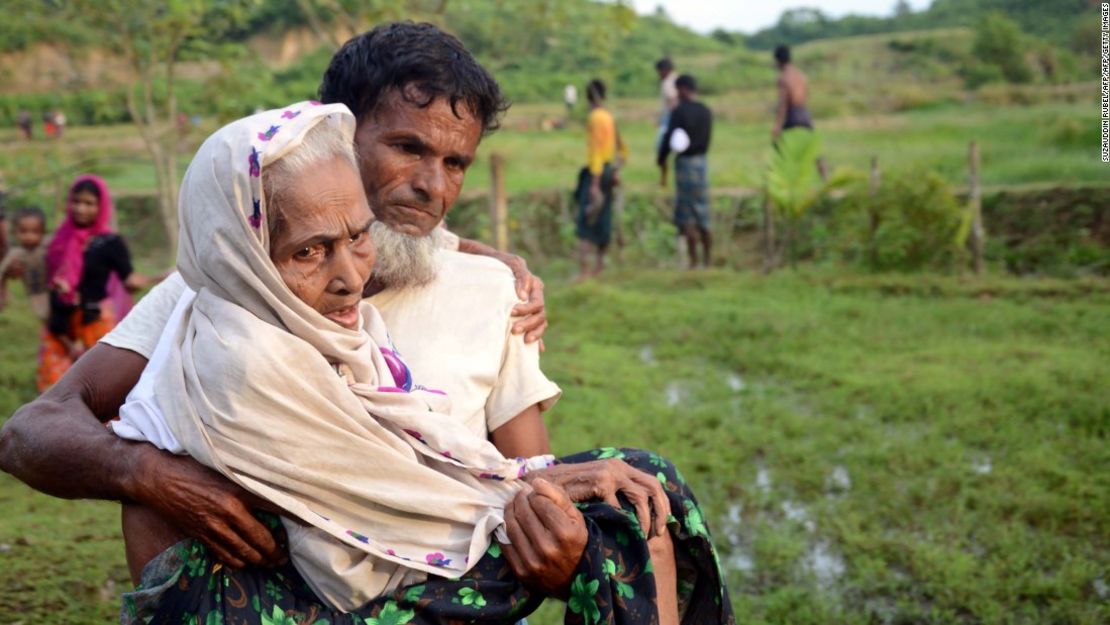 Un hombre rohinyá carga a su madre después de cruzar la frontera entre Bangladesh y Myanmar.