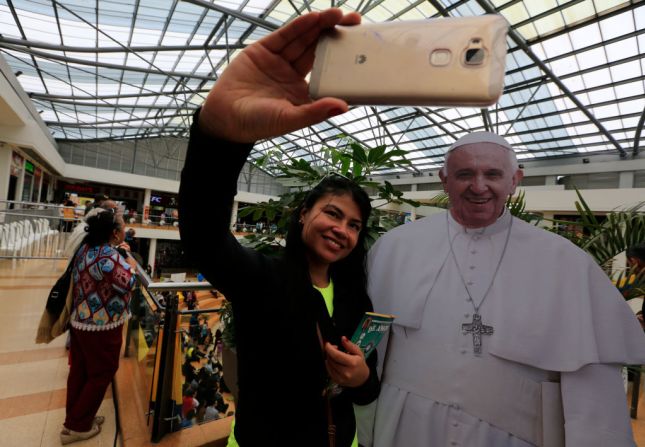 Una mujer se toma una selfie junto a una imagen de tamaño real del papa Francisco durante la ‘Confesatón’ realizada en Bogotá el 20 de agosto, para preparar la llegada del papa a Colombia.