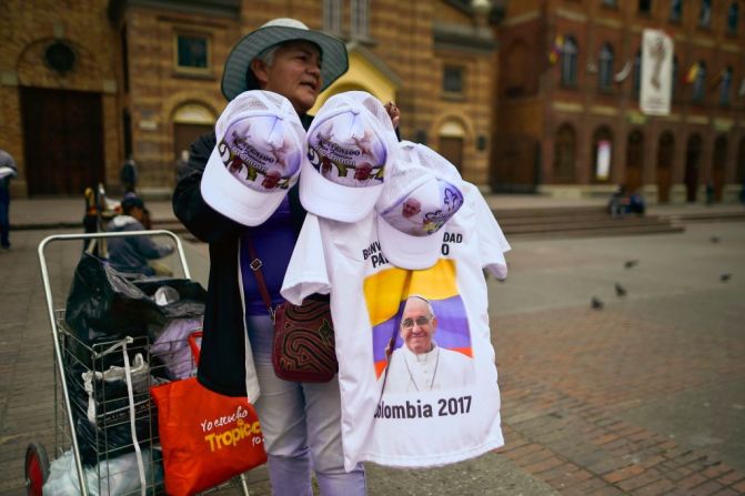 Esta mujer vende camisetas y sombreros con la imagen de Francisco en las calles de Bogotá un día antes de la llegada del papa a la capital colombiana.