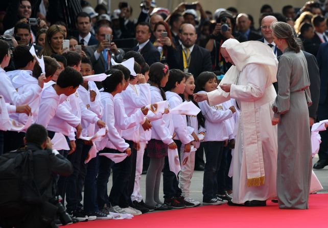 El papa saluda a niños a su llegada a la base militar CATAM tras ser bienvenido por el presidente juan Manuel Santos.