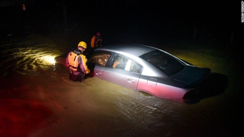 Equipos de emergencia revisan un auto inundado, sin ocupantes, en la noche del miércoles en Fajardo, Puerto Rico.