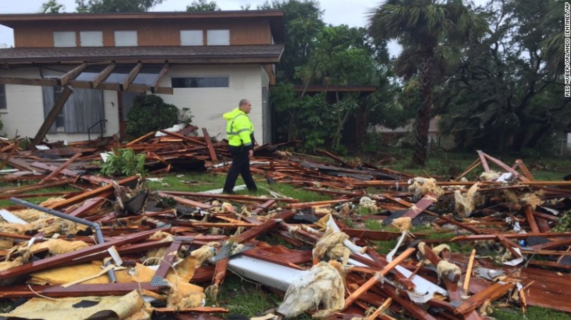 Un policía camina sobre los escombros de una casa de dos pisos que resultó destruida en Palm Bay, en el condado de Brevard (Florida), después de que un tornado azotó esa zona este domingo.