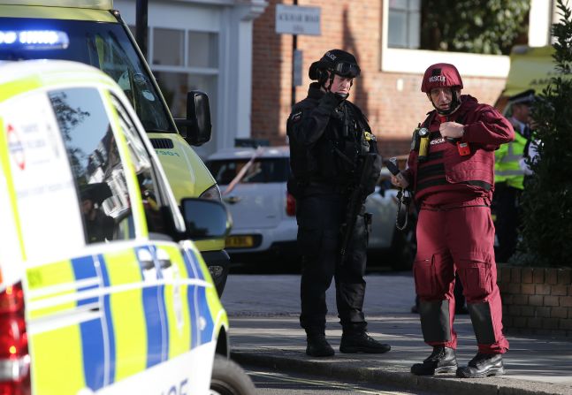 Un policía británico armado y un miembro de los servicios de emergencias se paran cerca de la estación Parsons Green al este de Londres donde ocurrió el incidente. En el dispositivo explosivo improvisado las autoridades encontraron un temporizador.