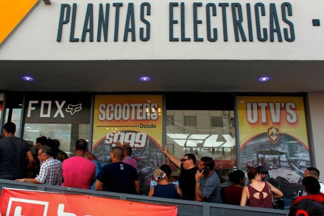 Una fila de clientes esperan la llegada de generadores de energía el 18 de septiembre en una tienda de deportes de San Juan, mientras María se acerca a Puerto Rico.