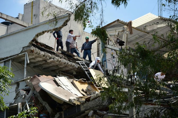 Algunas personas encima de uno de los edificios colapsados en Ciudad de México.