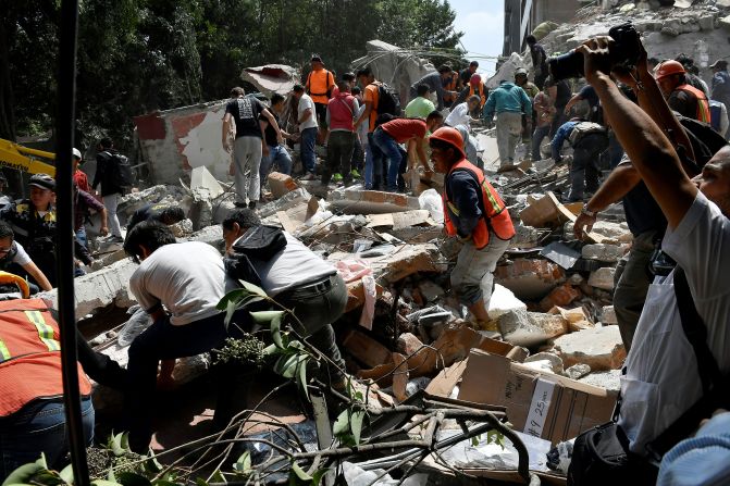 Equipos y ciudadanos tratan de remover los escombros de un edificio que colapsó durante el sismo.