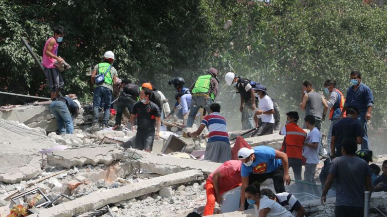 Algunas personas intentan remover escombros, luego de que un edificio de la calle de Monterrey en la esquina con Viaducto se derrumbara.