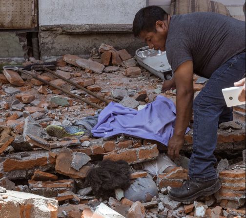 Un hombre intenta sacar a alguien que quedó sepultado entre los escombros de Puebla, tras el sismo de 7,1.