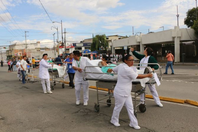 Personal médico traslada a pacientes en Puebla, tras el poderoso sismo.