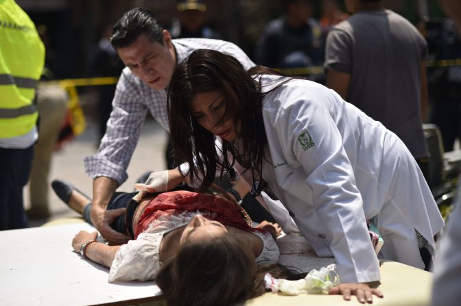 A las docenas de muertos se sumaron muchos heridos, como esta mujer que es atendida por una asistente médica en un espacio improvisado.