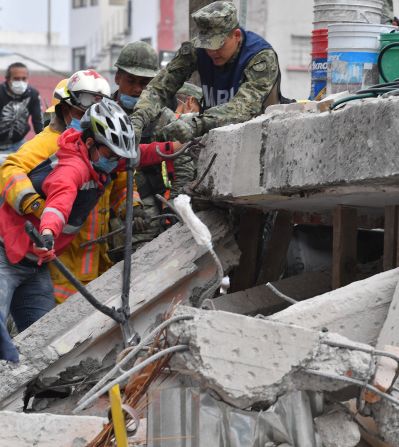 Un soldado, un bombero y una voluntaria buscan sobrevivientes en otro edificio colapsado por el sismo en la Ciudad de México.