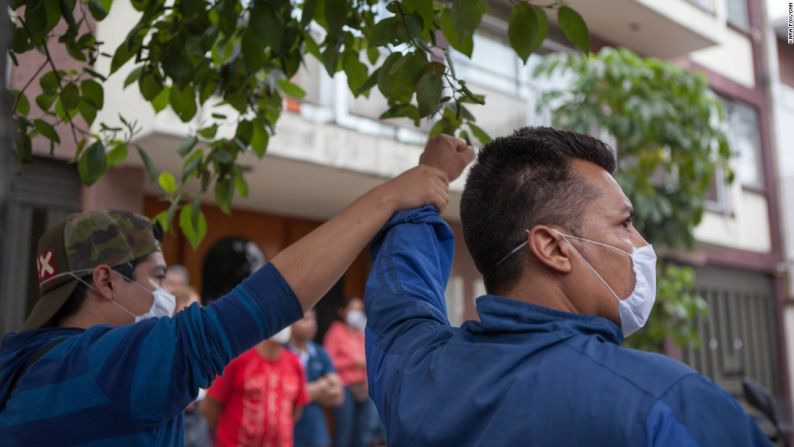 Dos voluntarios alzan su mano pidiendo silencio, en el momento en que los rescatistas oyeron los primeros sonidos que podían indicar que había personas con vida, enterradas bajo los escombros del destruido Colegio Enrique Rébsamen.