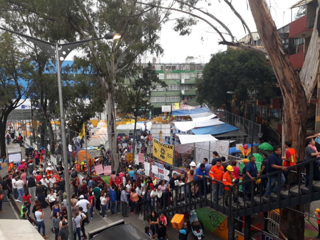 Rescatistas y voluntarios suben y bajan por un puente peatonal con picos y palas (Foto: Dainzú Patiño).