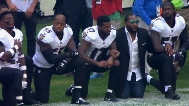 El retirado jugador de los Baltimore Ravens Ray Lewis, con abrigo, se unió a su antiguo equipo para protestar.