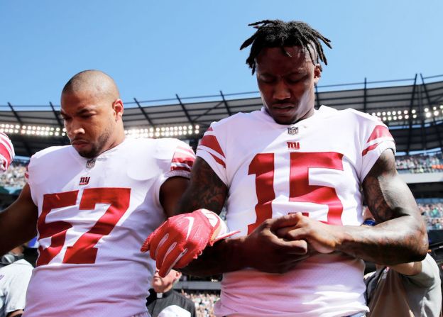 Keenan Robinson y Brandon Marshall de los New York Giants unieron sus brazos durante el himno antes de su partido contra los Philadelphia Eagles.