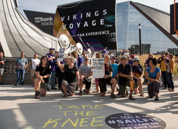 Manifestantes se hincan afuera del U.S. Bank Stadium antes del partido de los Minnesota Vikings en Minneapolis, Minnesota.